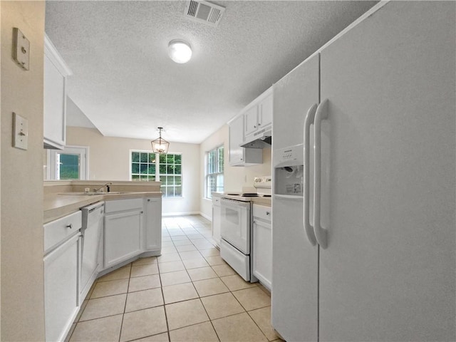 kitchen featuring hanging light fixtures, white cabinets, a textured ceiling, white appliances, and light tile patterned floors