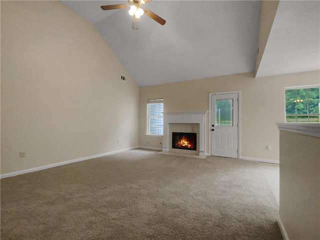 unfurnished living room with a tiled fireplace, ceiling fan, light carpet, and vaulted ceiling