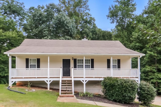 view of front of home with a front lawn, roof with shingles, and covered porch