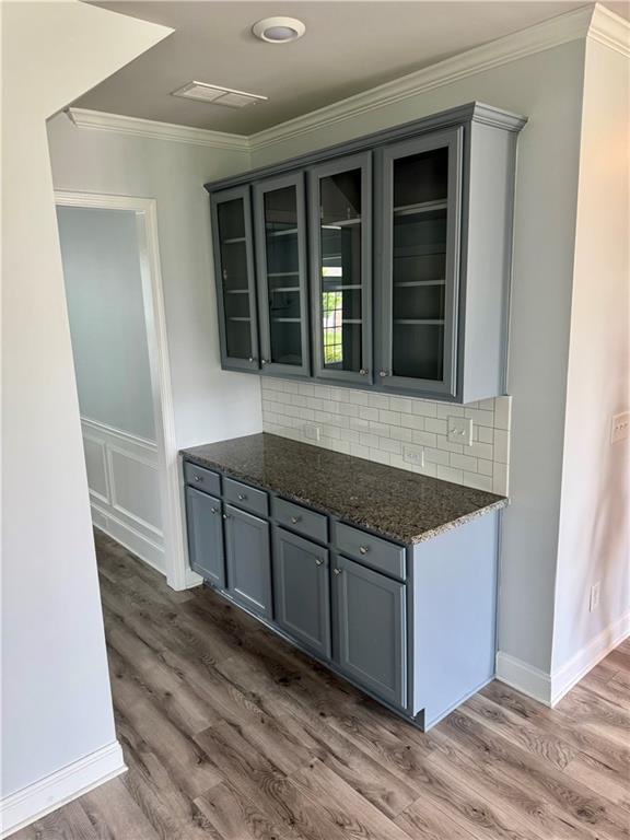 4416 Birch Meadow Trl, Gainesville, GA 30504 - bar area featuring crown molding, dark wood finished floors, tasteful backsplash, and baseboards