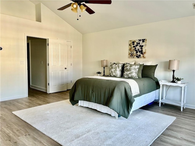 bedroom featuring ceiling fan, vaulted ceiling, baseboards, and wood finished floors