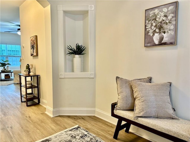 sitting room with light wood-style floors, ceiling fan, and baseboards