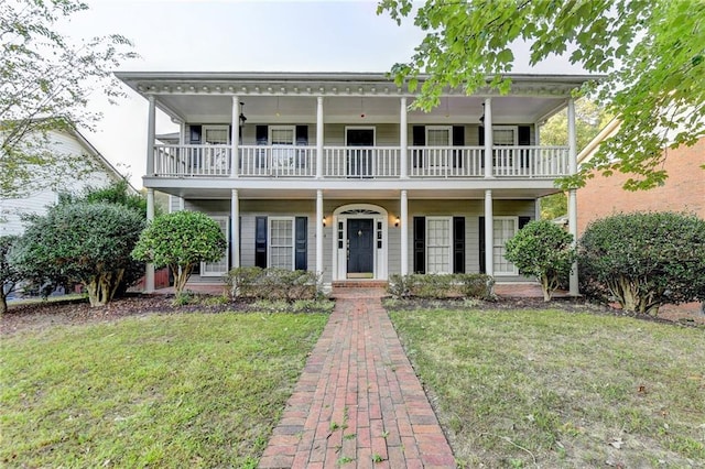 view of front of property with a porch, a front yard, and a balcony