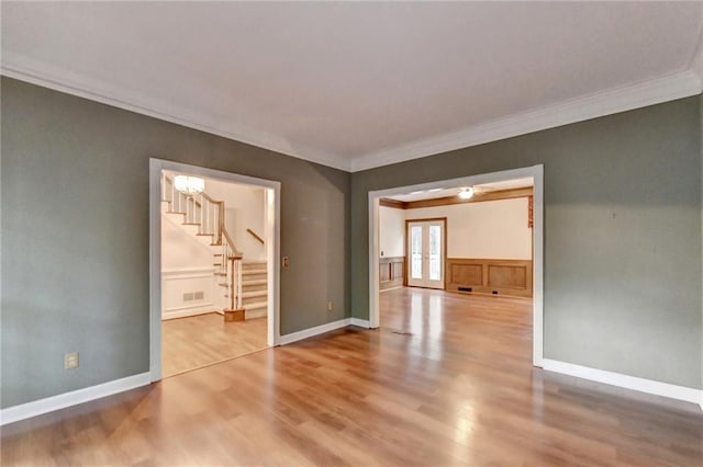 unfurnished room featuring french doors, crown molding, and light hardwood / wood-style flooring