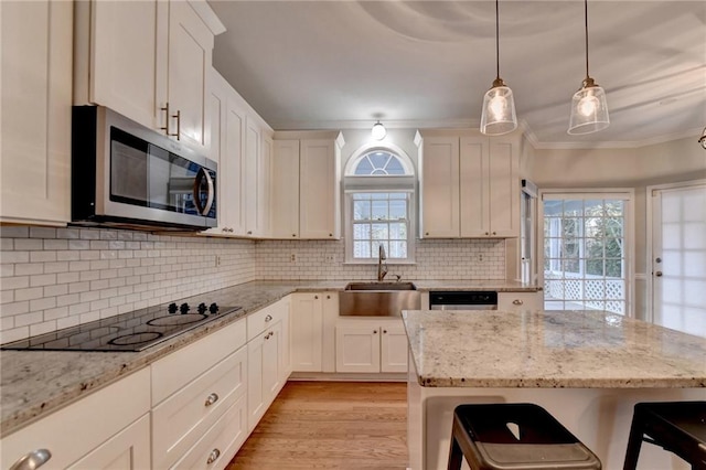 kitchen featuring appliances with stainless steel finishes, backsplash, white cabinetry, and a wealth of natural light