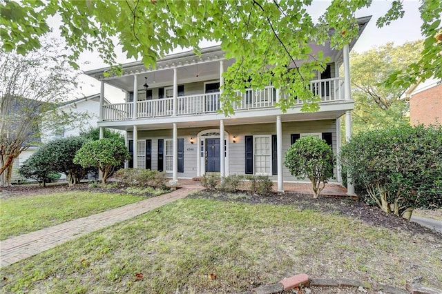 view of front of home with a front yard and a balcony