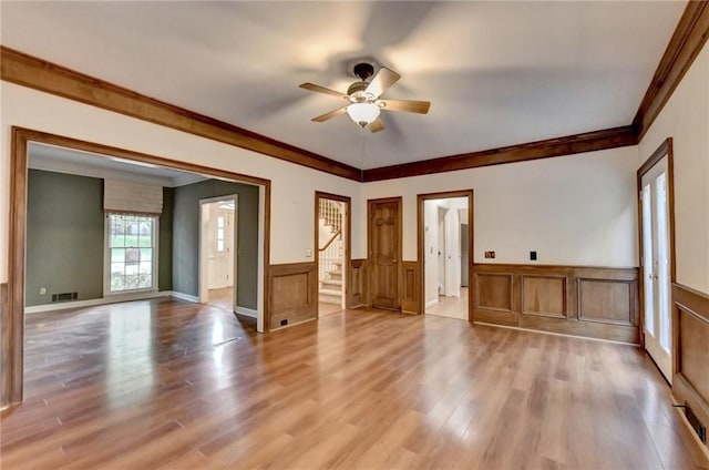 empty room featuring ceiling fan, crown molding, and light hardwood / wood-style floors