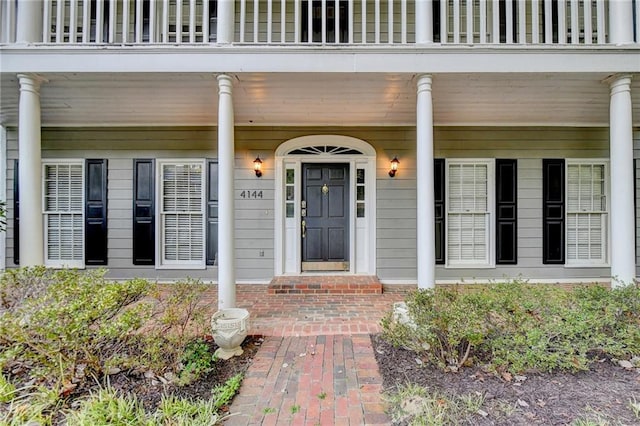 property entrance featuring a porch and a balcony