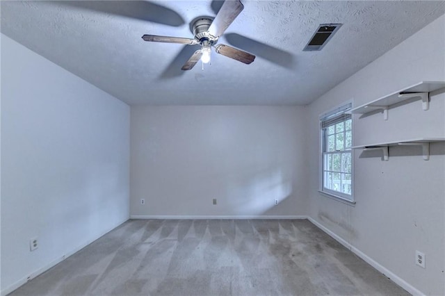 spare room featuring carpet, a textured ceiling, and ceiling fan