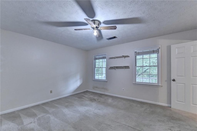 carpeted empty room with ceiling fan and a textured ceiling