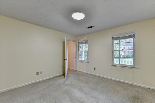 spare room with light colored carpet and plenty of natural light