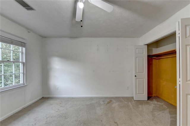 unfurnished bedroom featuring ceiling fan, a closet, and light colored carpet