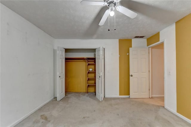 unfurnished bedroom featuring ceiling fan, a textured ceiling, a closet, and light carpet