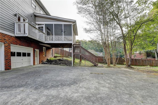 view of side of home with a garage and a sunroom