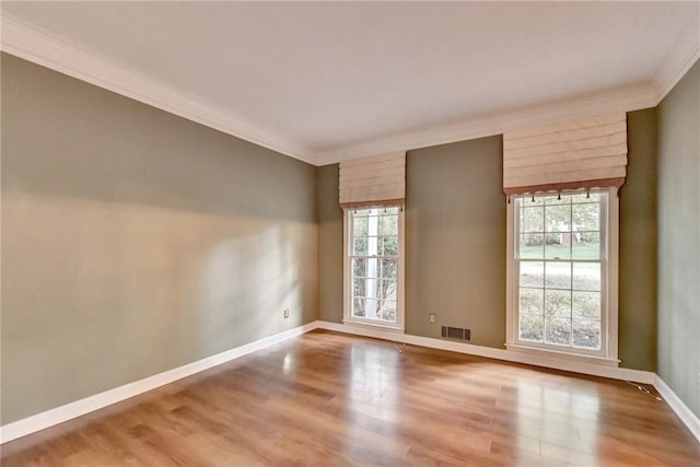 unfurnished room featuring plenty of natural light, hardwood / wood-style floors, and crown molding