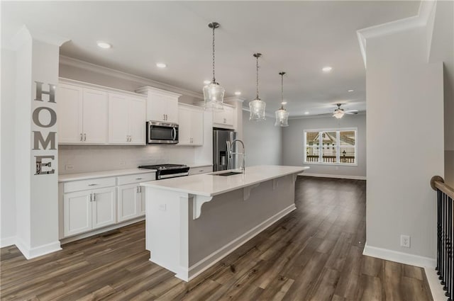 kitchen with white cabinets, appliances with stainless steel finishes, ceiling fan, and a kitchen island with sink