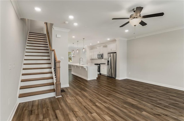 unfurnished living room featuring ornamental molding, ceiling fan, dark hardwood / wood-style flooring, and sink