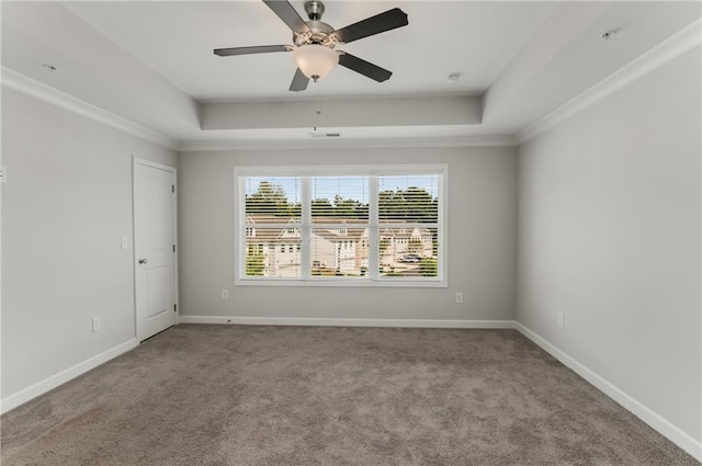 carpeted spare room featuring ceiling fan, ornamental molding, and a tray ceiling