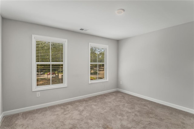 unfurnished room featuring light carpet