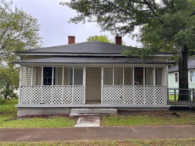 29 Ivy St, Porterdale, GA 30014 - view of front of home with a chimney, a porch, and roof with shingles