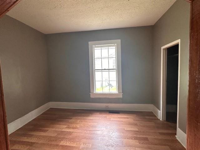 29 Ivy St, Porterdale, GA 30014 - empty room featuring healthy amount of natural light, wood finished floors, a textured ceiling, and baseboards