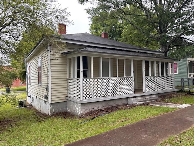 29 Ivy St, Porterdale, GA 30014 - view of property exterior featuring covered porch, a chimney, roof with shingles, and a yard