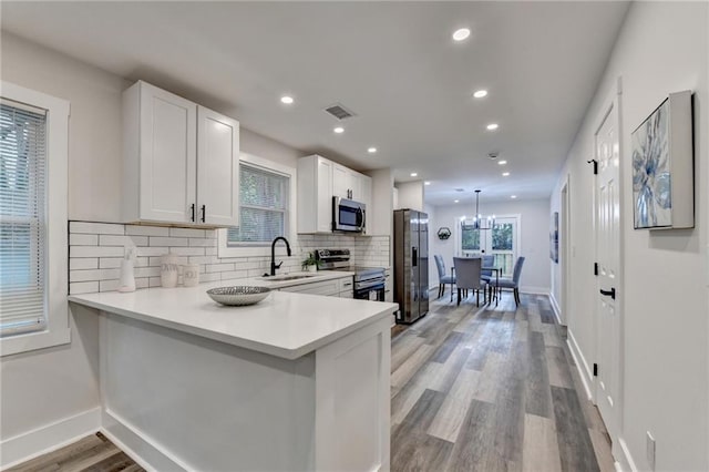 538 Center Hill Ave NW, Atlanta, GA 30318 - kitchen featuring a sink, light countertops, appliances with stainless steel finishes, white cabinetry, and decorative backsplash