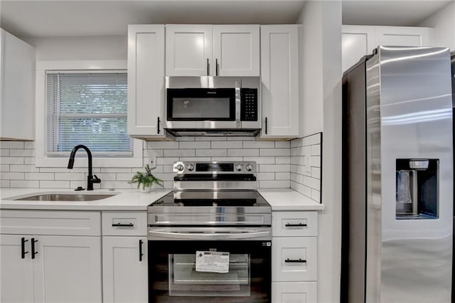 538 Center Hill Ave NW, Atlanta, GA 30318 - kitchen with tasteful backsplash, white cabinets, a sink, light countertops, and appliances with stainless steel finishes