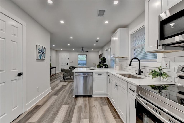 538 Center Hill Ave NW, Atlanta, GA 30318 - kitchen with appliances with stainless steel finishes, white cabinetry, light wood-style floors, ceiling fan, and a sink