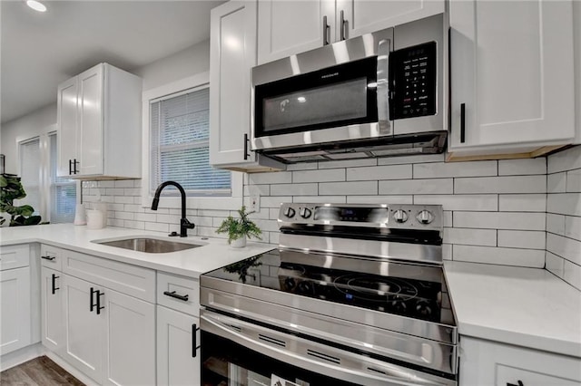 538 Center Hill Ave NW, Atlanta, GA 30318 - kitchen featuring light countertops, white cabinetry, decorative backsplash, stainless steel appliances, and a sink