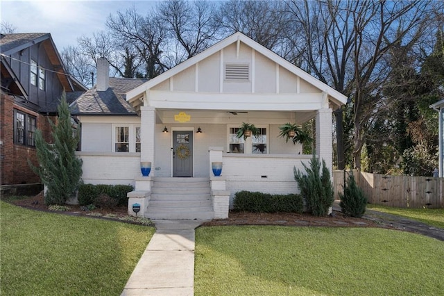 view of front of house with covered porch and a front lawn