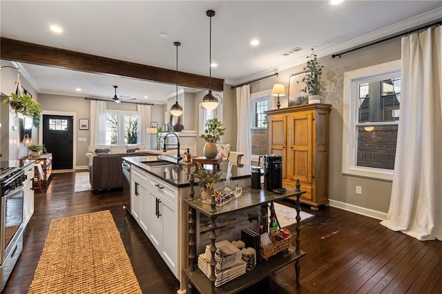 kitchen featuring sink, an island with sink, white cabinets, dark hardwood / wood-style flooring, and decorative light fixtures