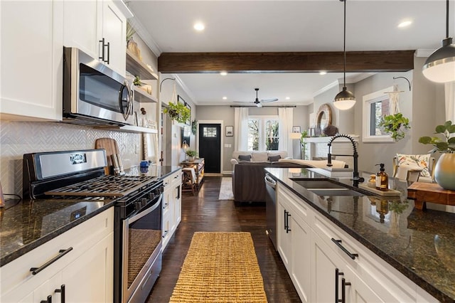 kitchen with stainless steel appliances, sink, hanging light fixtures, and white cabinets