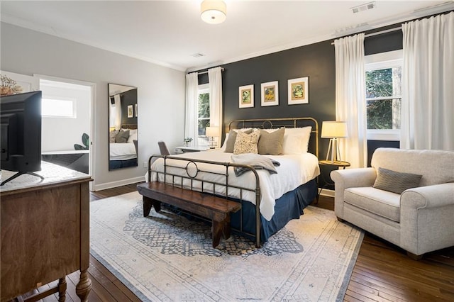 bedroom featuring crown molding and dark hardwood / wood-style floors