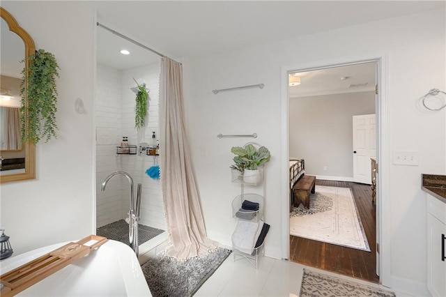 bathroom with vanity, wood-type flooring, and a tub