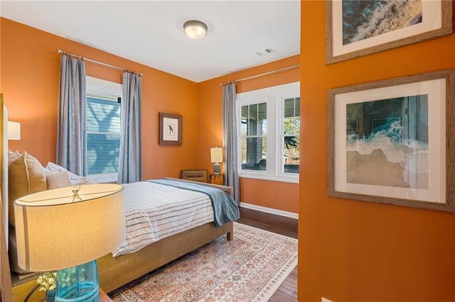 bedroom featuring multiple windows and wood-type flooring