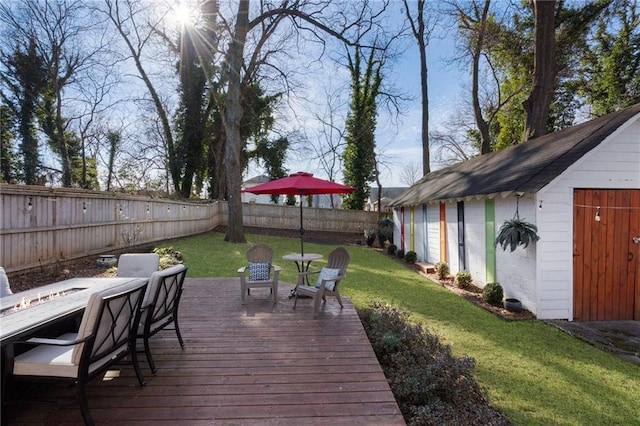 wooden terrace featuring an outbuilding and a lawn