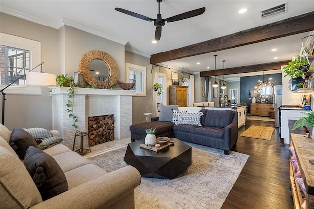 living room with crown molding, a fireplace, dark hardwood / wood-style floors, and beam ceiling