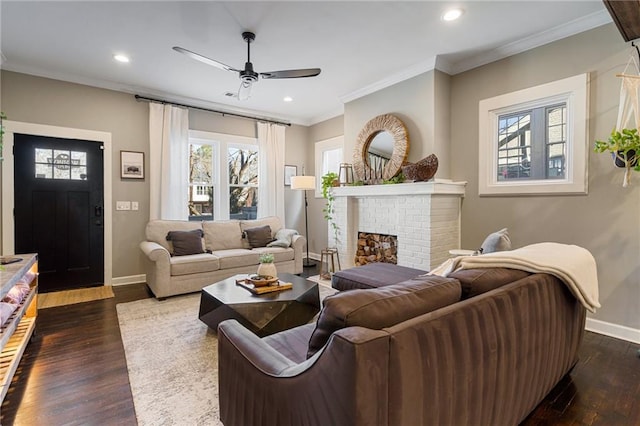 living room with ceiling fan, ornamental molding, dark hardwood / wood-style floors, and a brick fireplace