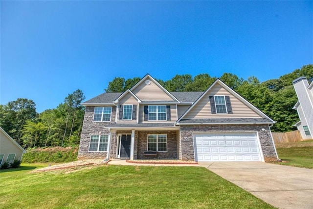 view of front of home with stone siding, concrete driveway, and a front yard