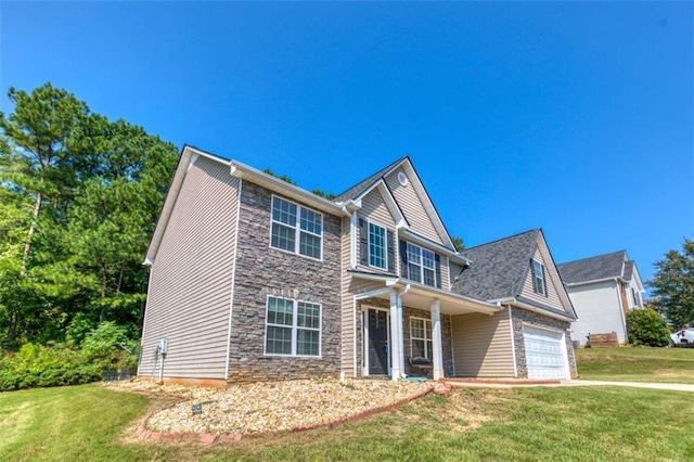 view of front facade with an attached garage, stone siding, a front yard, and driveway