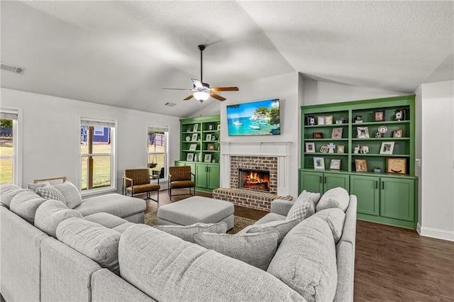 137 Evergreen Ridge Ct, Statham, GA 30666 - living room with lofted ceiling, ceiling fan, a textured ceiling, a brick fireplace, and dark wood-style flooring