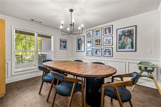 137 Evergreen Ridge Ct, Statham, GA 30666 - dining room featuring a chandelier, dark wood-style floors, ornamental molding, a textured ceiling, and a decorative wall