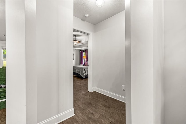 137 Evergreen Ridge Ct, Statham, GA 30666 - corridor featuring a textured ceiling, baseboards, and dark wood-style floors