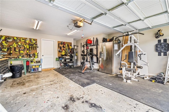 137 Evergreen Ridge Ct, Statham, GA 30666 - garage with stainless steel refrigerator with ice dispenser, a garage door opener, and a workshop area