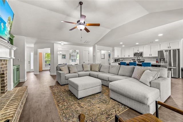 137 Evergreen Ridge Ct, Statham, GA 30666 - living area with lofted ceiling, ceiling fan, dark wood finished floors, recessed lighting, and a brick fireplace