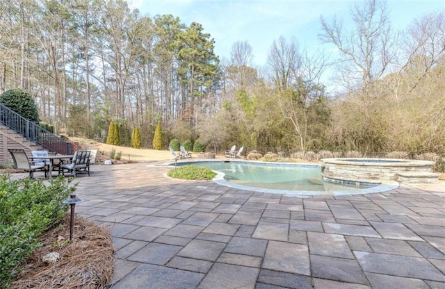 view of pool featuring a patio area and an in ground hot tub