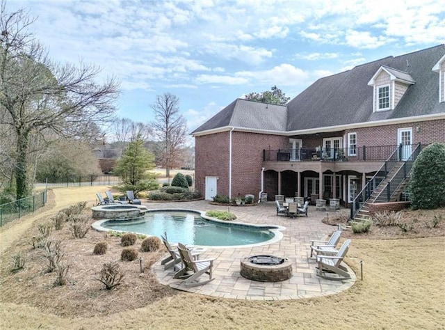 view of swimming pool featuring a patio, an in ground hot tub, and a fire pit