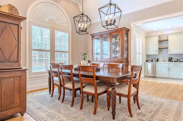 dining room with crown molding and light wood-type flooring