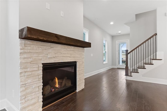 unfurnished living room featuring a stone fireplace and hardwood / wood-style flooring